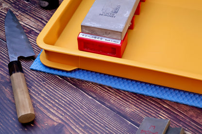 Sharpening Station Kit in use — orange soaking tray, red whetstone holder with Morihei stone, Japanese knife on wood surface