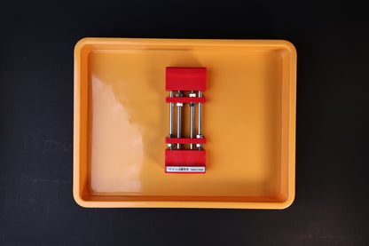 Sharpening Station Kit overhead view — red adjustable whetstone holder centered in orange soaking tray with water