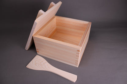 square ohitsu with wood rice scooper beside and wood lid leaning against container by youbi