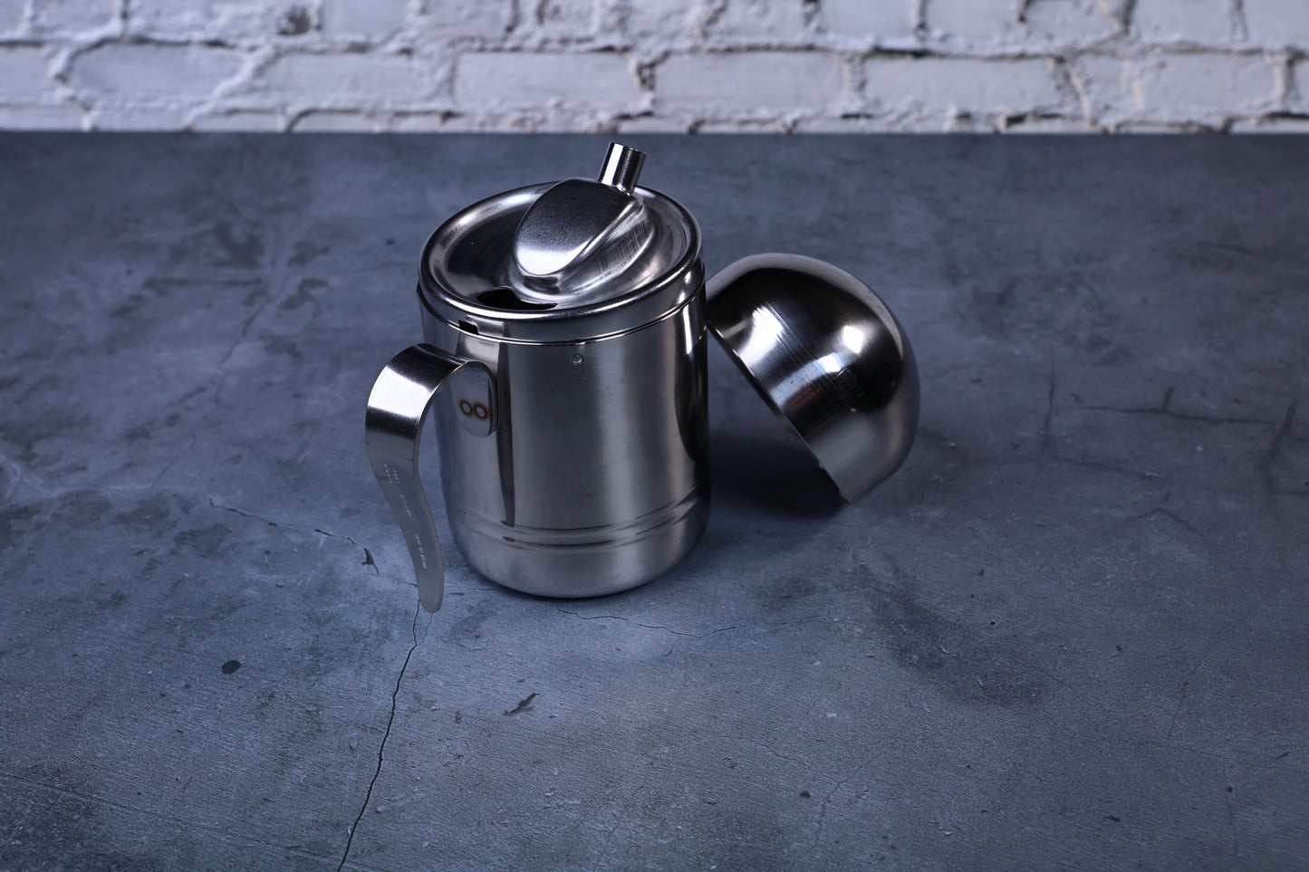 Stainless steel oil cruet small — front view with dome lid removed showing pour spout and open top