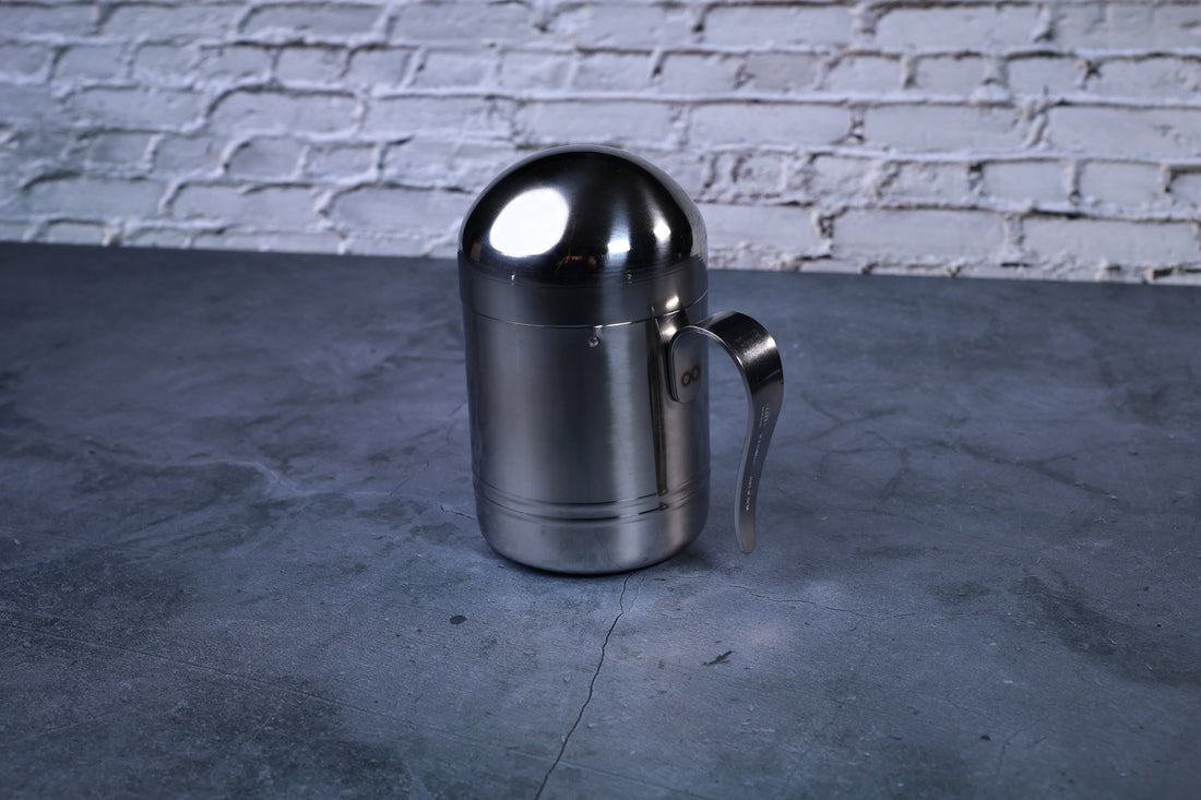 Stainless steel oil cruet small — full side view with dome lid on showing cylindrical body and handle