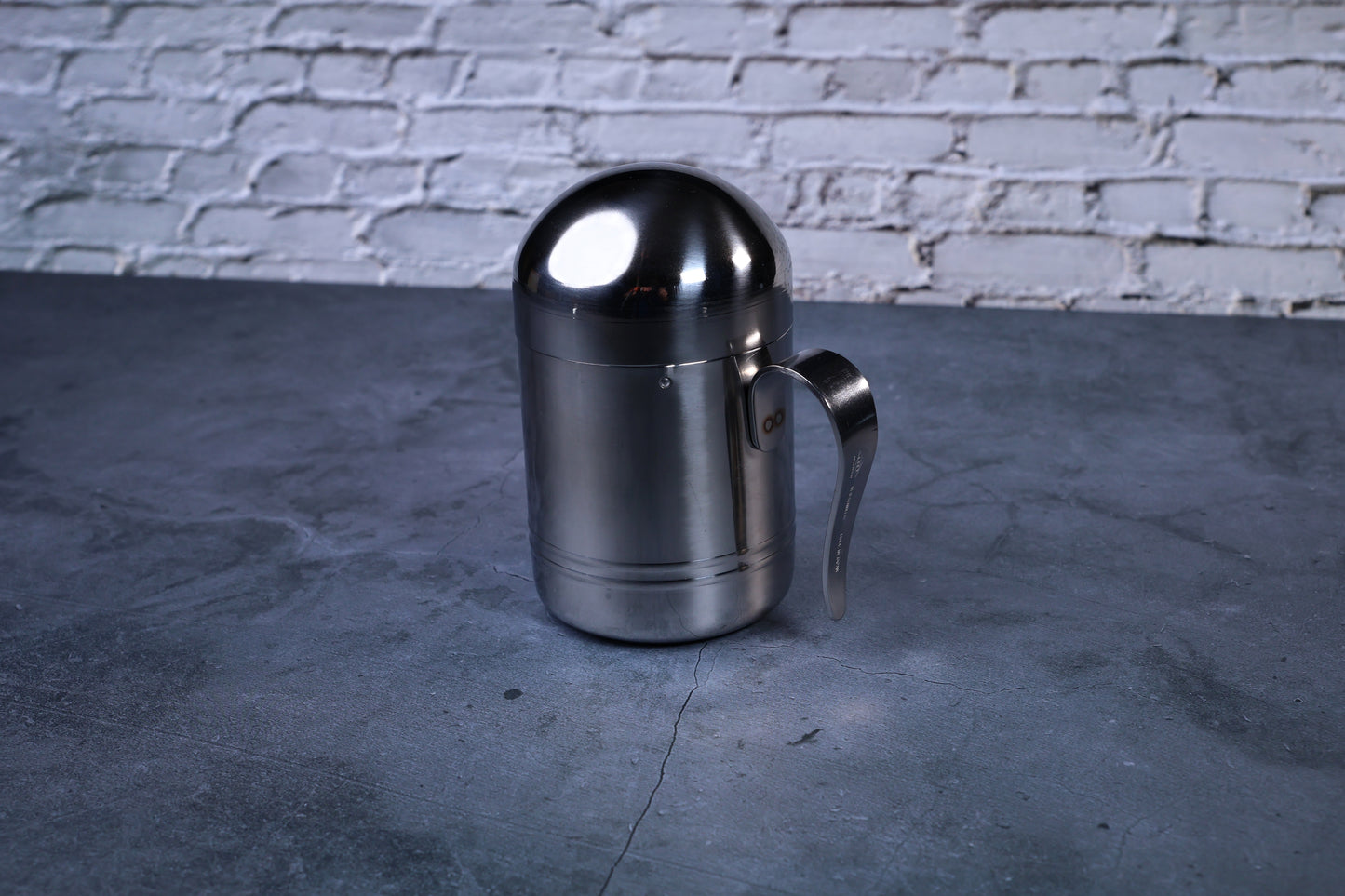 Stainless steel oil cruet small — full side view with dome lid on showing cylindrical body and handle