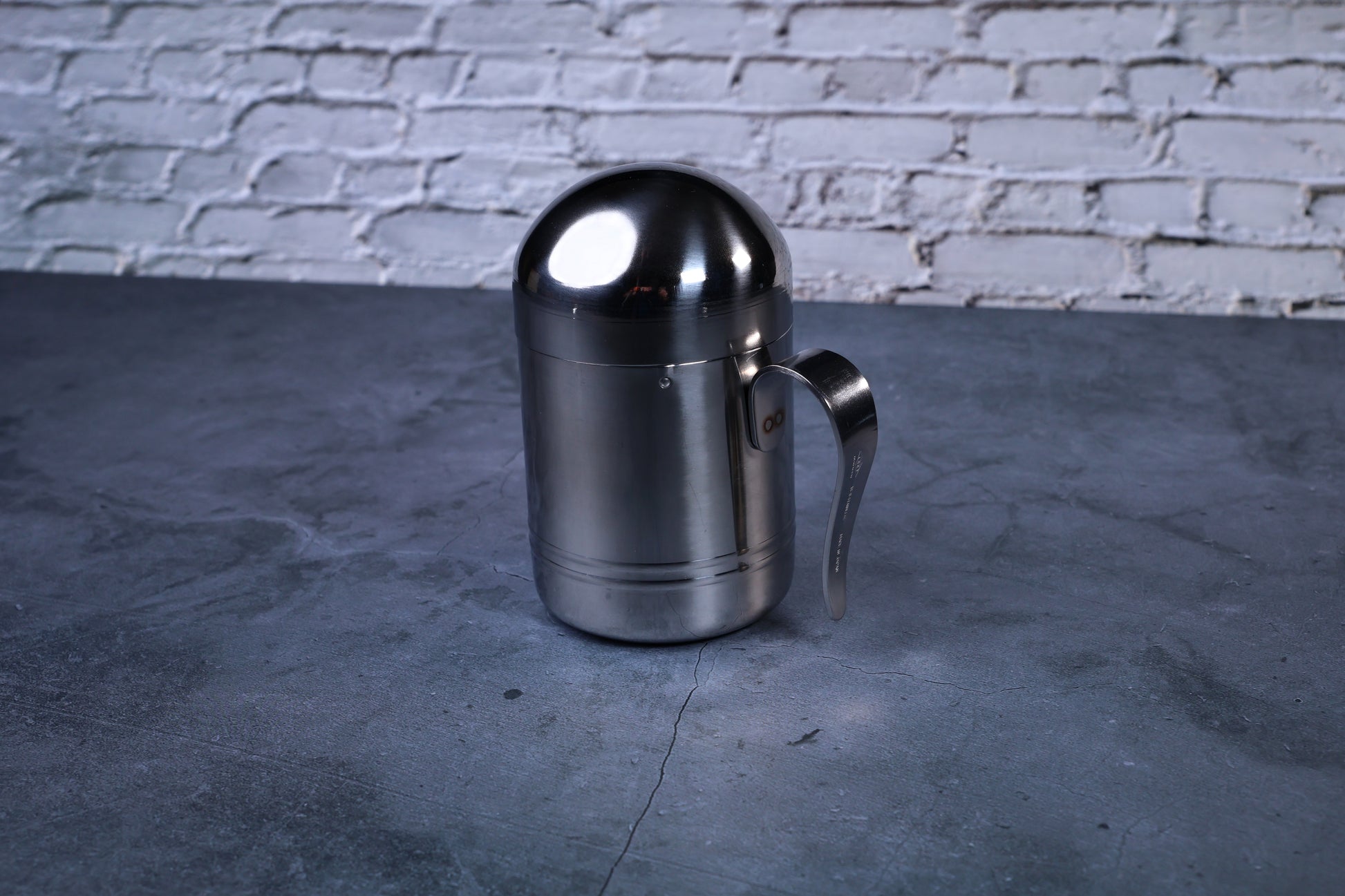 Stainless steel oil cruet small — full side view with dome lid on showing cylindrical body and handle