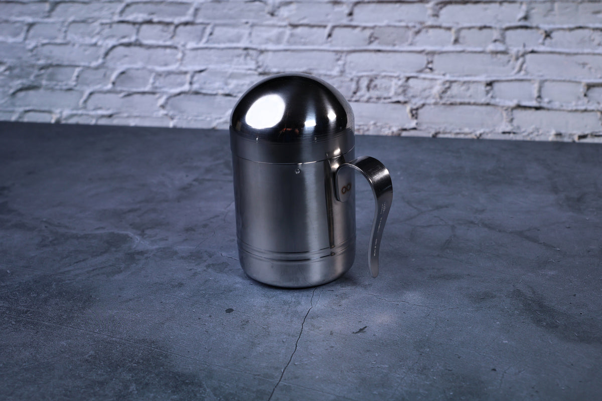 Stainless steel oil cruet small — full side view with dome lid on showing cylindrical body and handle