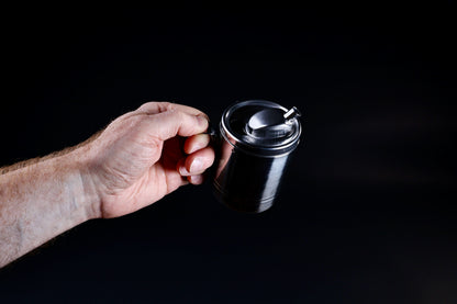 Stainless steel oil cruet small — held by handle in upright position showing full body and spout from above