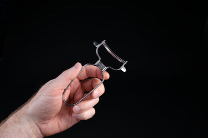 Stainless steel vegetable peeler — wire frame handle, swivel blade, and 18-8 stainless stamp held in hand