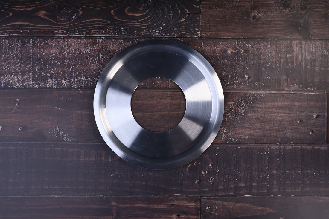 Stainless steel steam ring 21cm shown from above with its open center on a dark wood surface