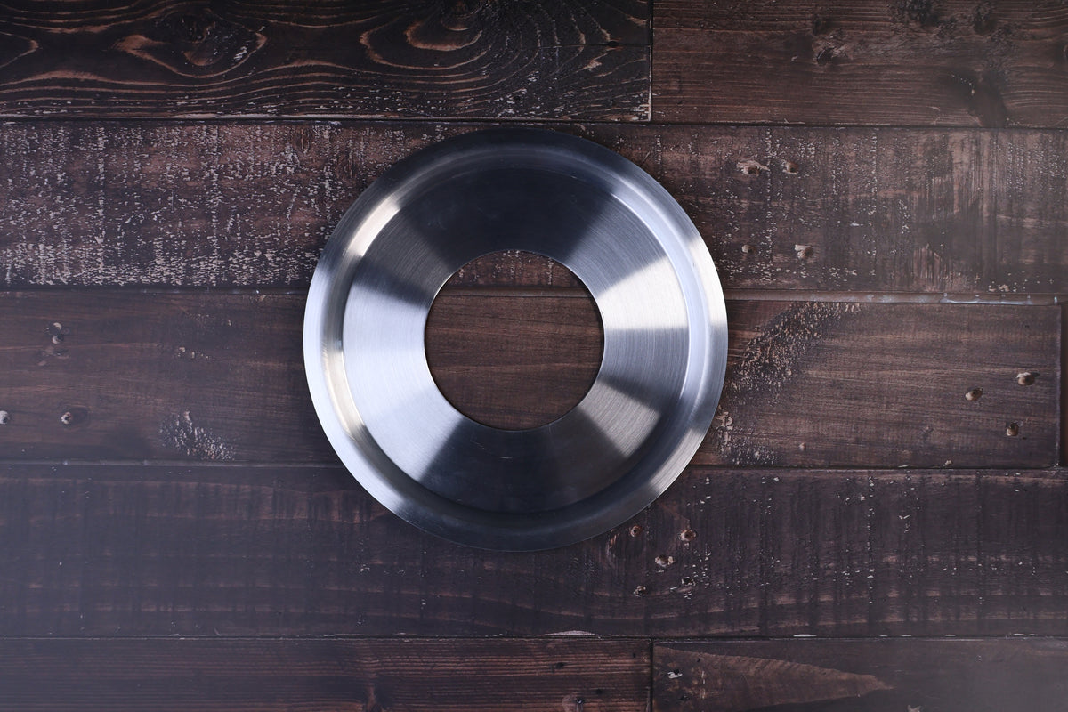 Stainless steel steam ring 21cm shown from above with its open center on a dark wood surface