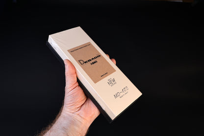 Suehiro Debado MD-400 #4000 sharpening stone — held in hand showing stone body and attached rubber base