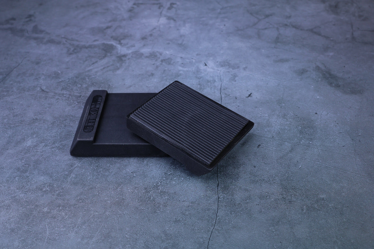 Suehiro rubber whetstone base with ribbed non-slip insert pad resting on top, showing grip texture detail