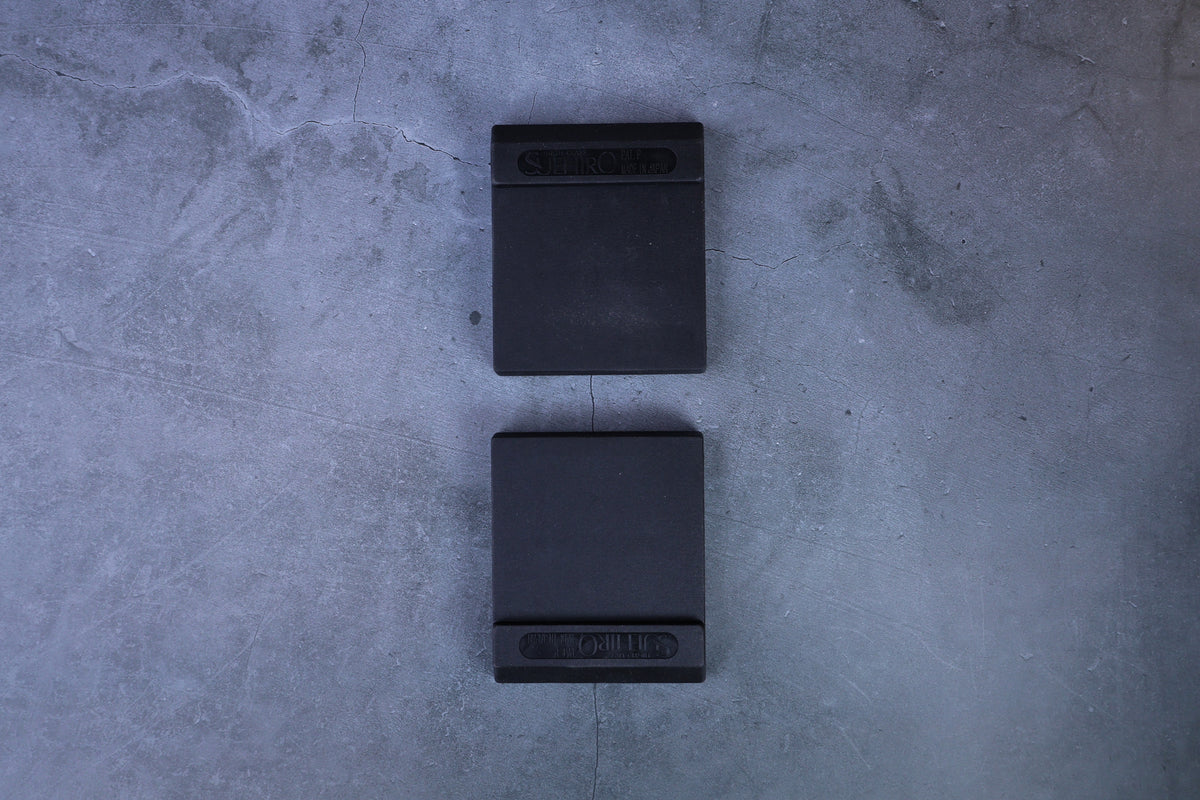 Two Suehiro rubber whetstone bases arranged vertically, straight overhead view showing both from above