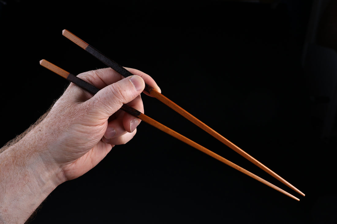 Suri urushi cooking chopsticks 30cm — full length held in hand showing grip position and tapered tips