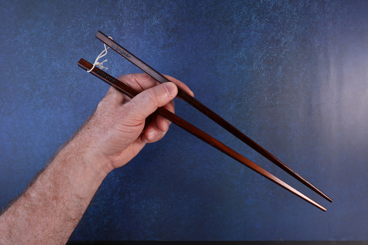 Suri Urushi cooking chopsticks 33cm — held in hand showing grip position and full length