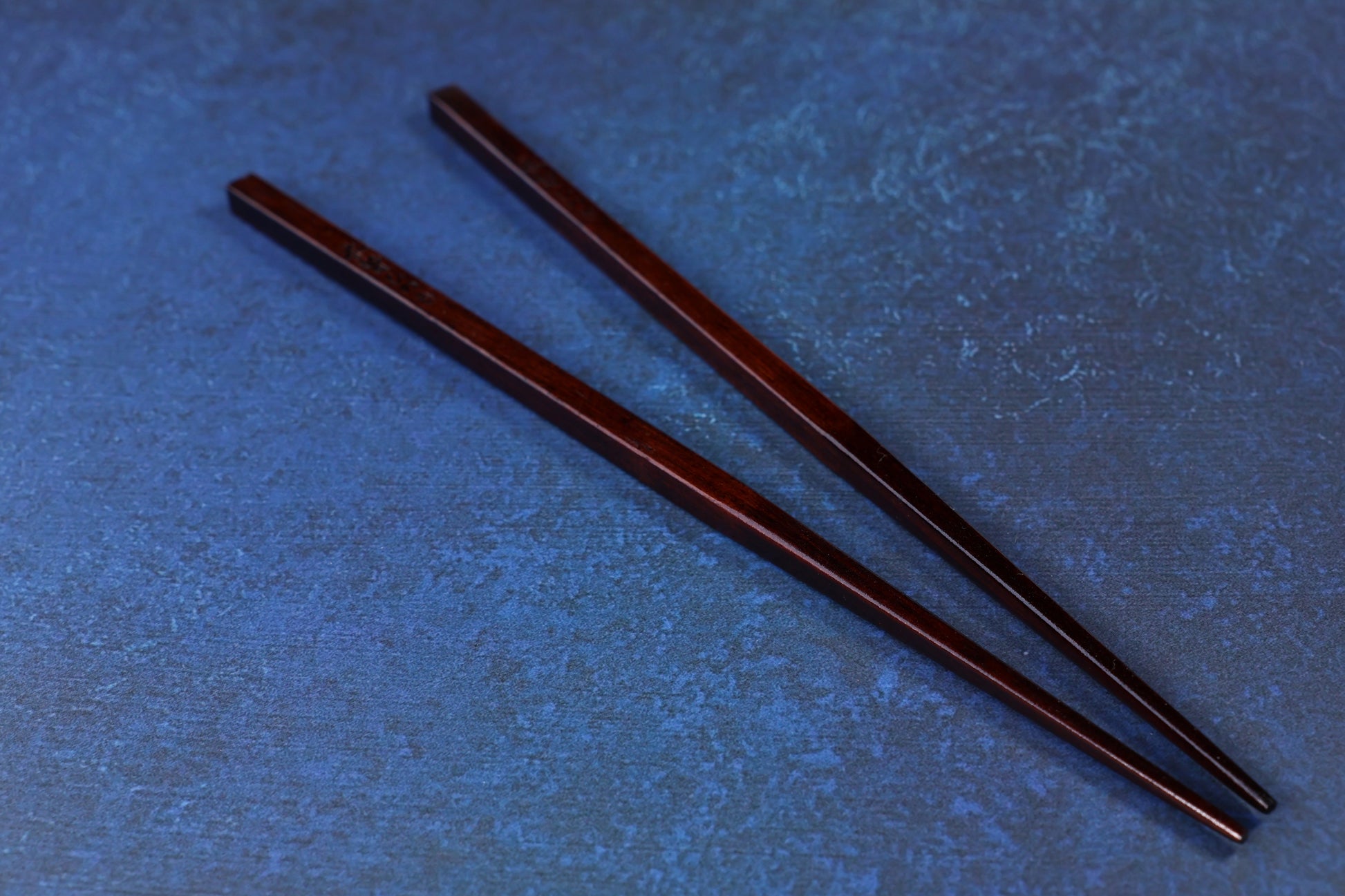 Suri Urushi Hinoki chopsticks 22cm showing squared handle ends and urushi lacquer finish on blue surface