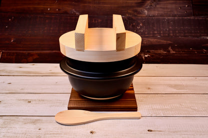 Suzuki Co. Hagama Rice Cooker 3-Cup — complete set front view on dark wood trivet