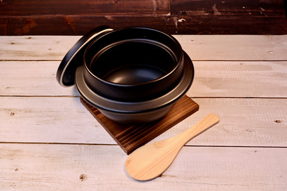 Suzuki Co. Hagama Rice Cooker 3 Cup  lid removed showing empty dark interior on trivet