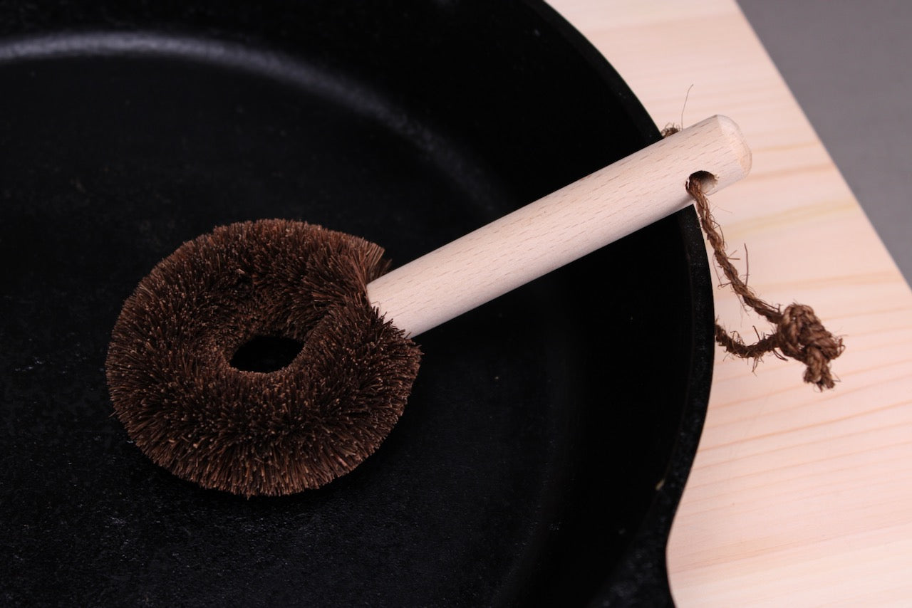 japanese kitchenware tawashi coarse fibered wood handled cleaning brush with hanging loop inside castiron pan for scrubbing 