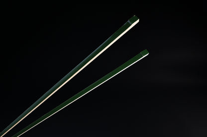 Tenbushi dark green bamboo chopsticks top ends close against black, showing square green lacquered grip ends