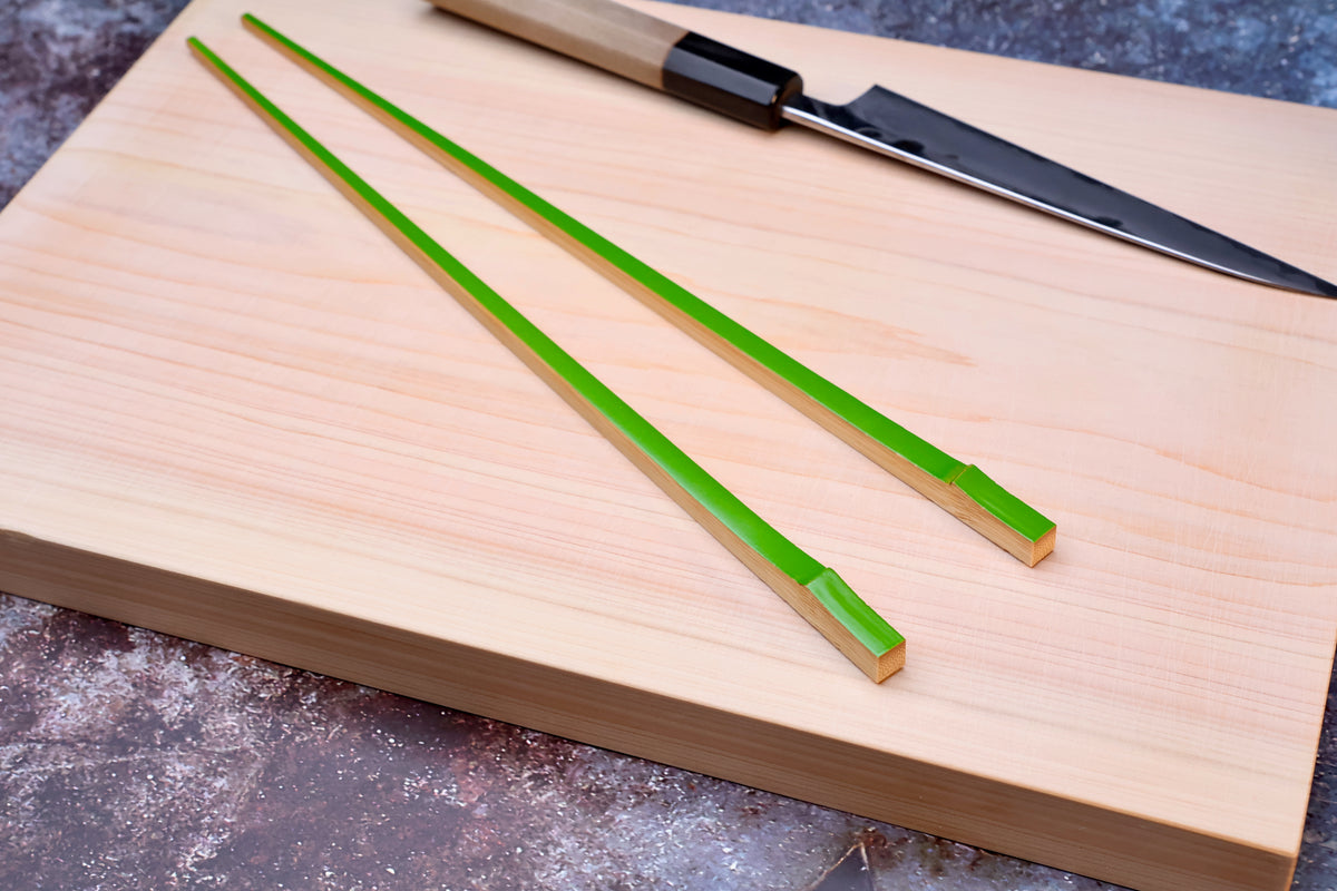 Tenbushi light green bamboo chopsticks on hinoki cutting board with Japanese knife, styled kitchen scene