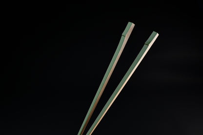 Tenbushi light green bamboo chopsticks top ends close against black, showing square green lacquered grip ends