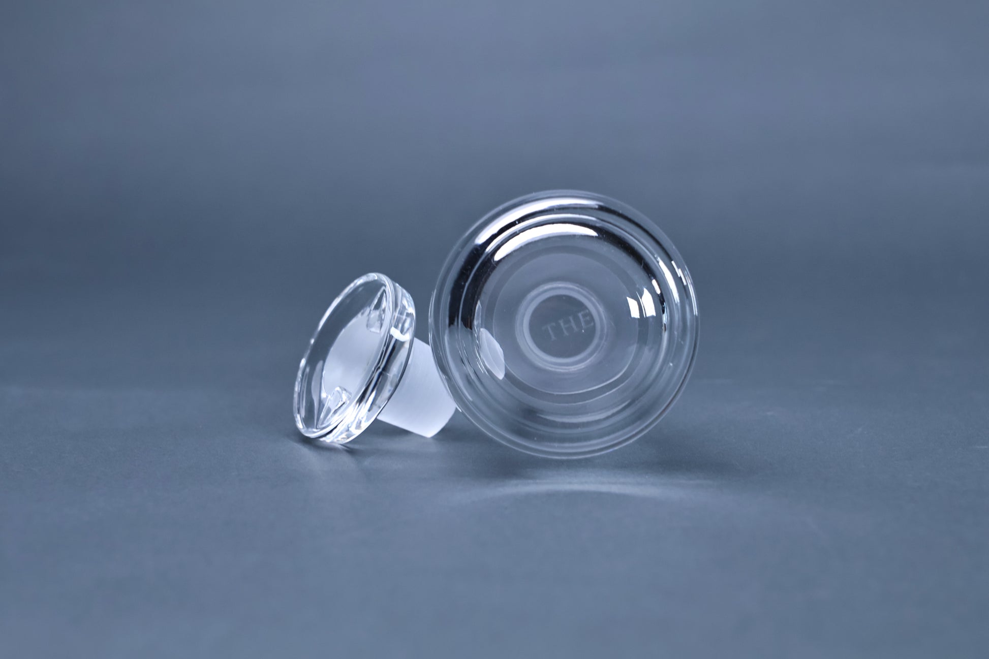 THE soy sauce cruet base showing THE brand engraving and stopper detail on grey background