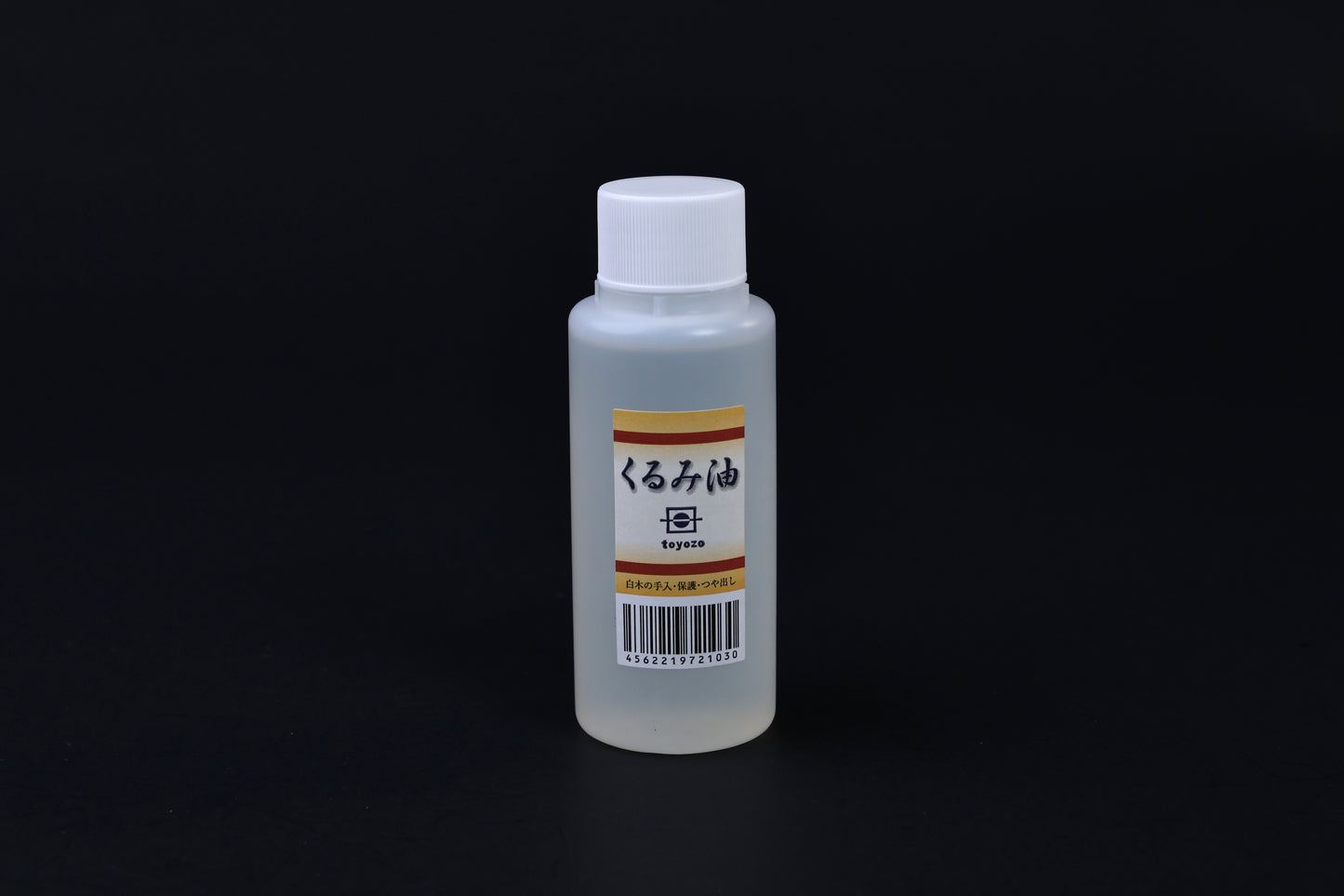 Toyozo kurumi walnut oil bottle held in hand showing size and Japanese label on black background