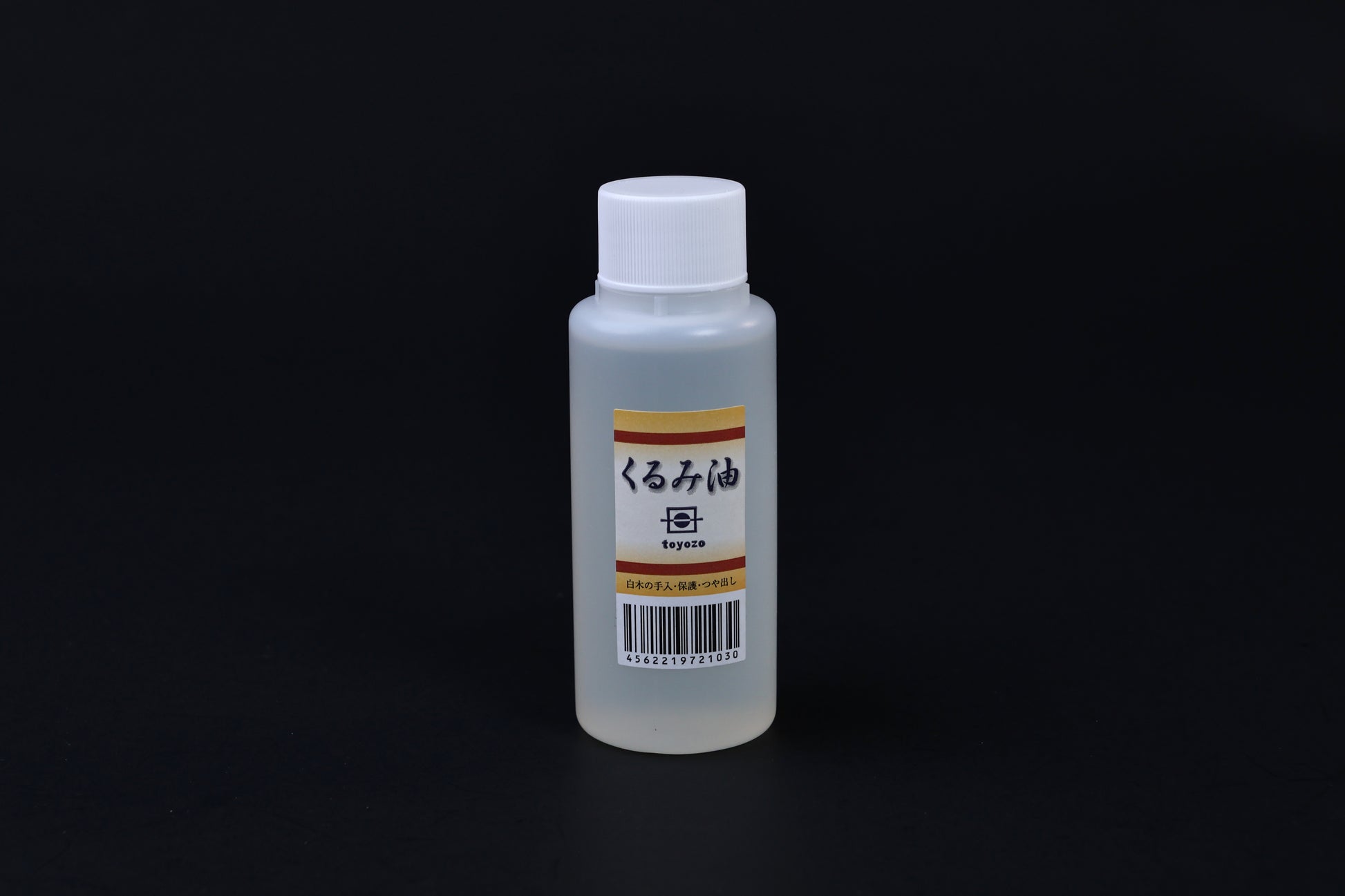 Toyozo kurumi walnut oil bottle held in hand showing size and Japanese label on black background