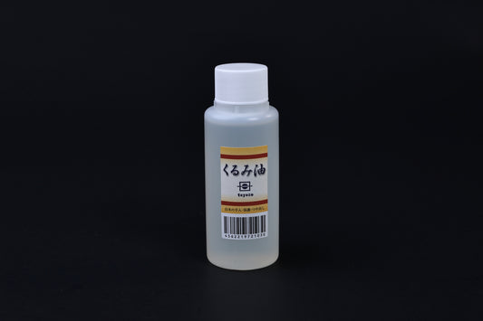 Toyozo kurumi walnut oil bottle held in hand showing size and Japanese label on black background