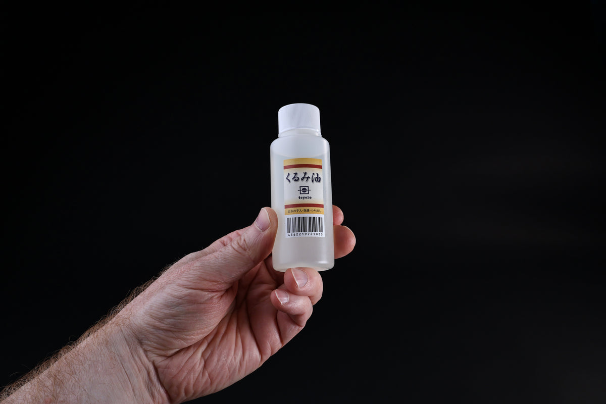 Toyozo kurumi walnut oil bottle standing upright, Japanese label clearly visible on black background
