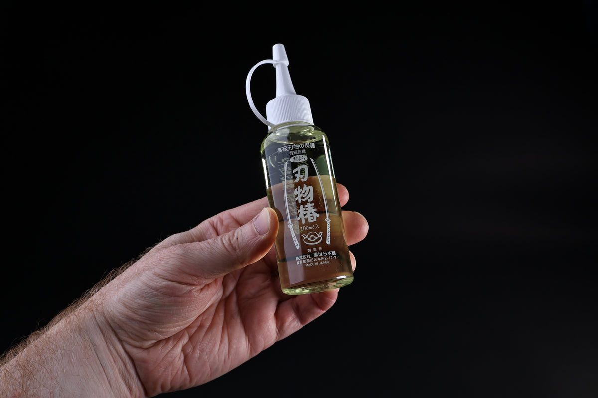 Tsubaki oil for knives and iron pans 100ml — Japanese label and applicator bottle held in hand