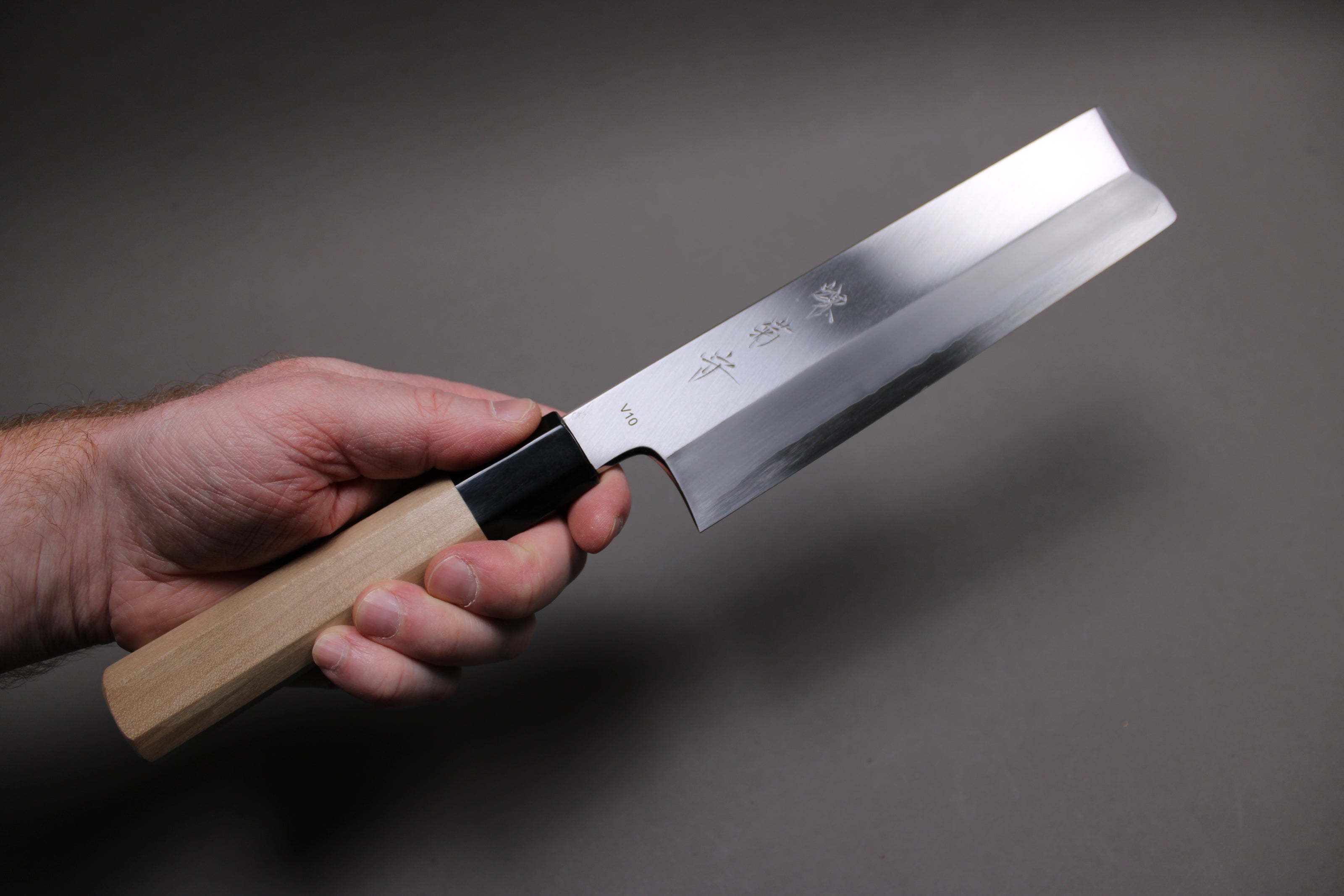 hand holding 195mm single bevel usuba showing shinogi line