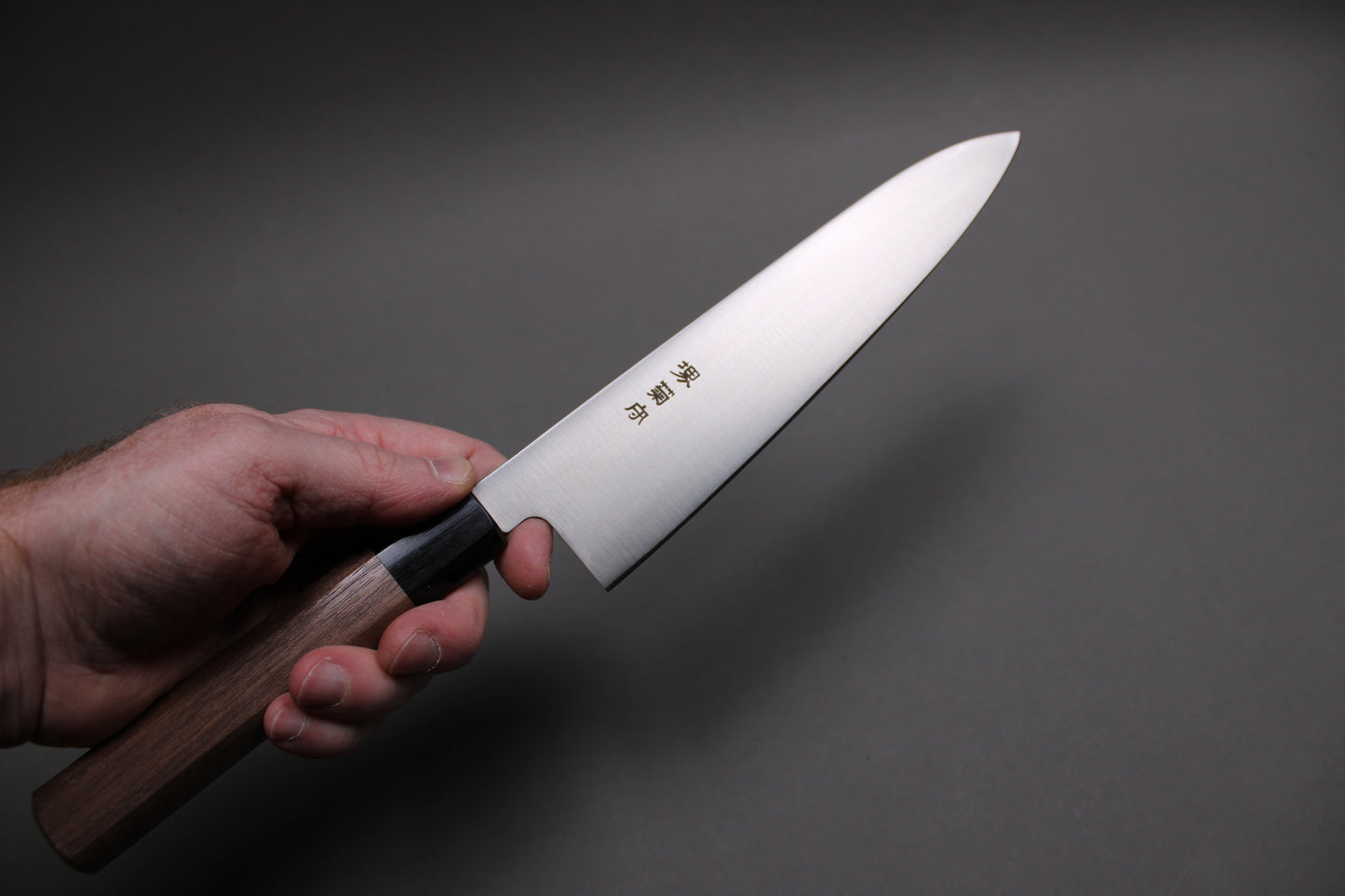 wasiki gyuto knife held in hand showing knife profile and kawamura hamono kanji