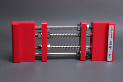 marie whetstone holder red rectangular shaped on its side showing red pvc body stainless steel rods springs grey backdrop