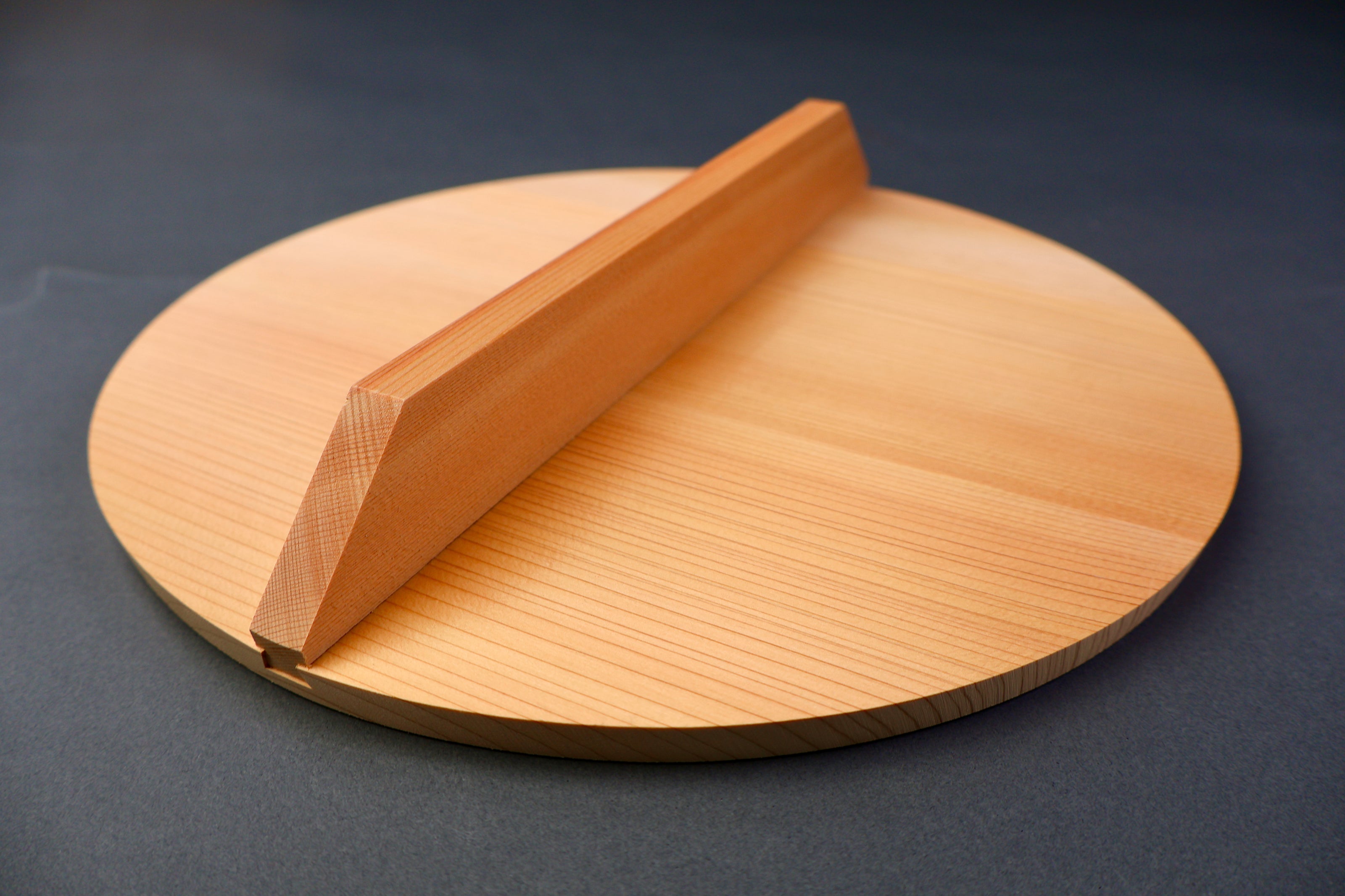 closeup shot of yellowish gold colored wooden drop lid grey background