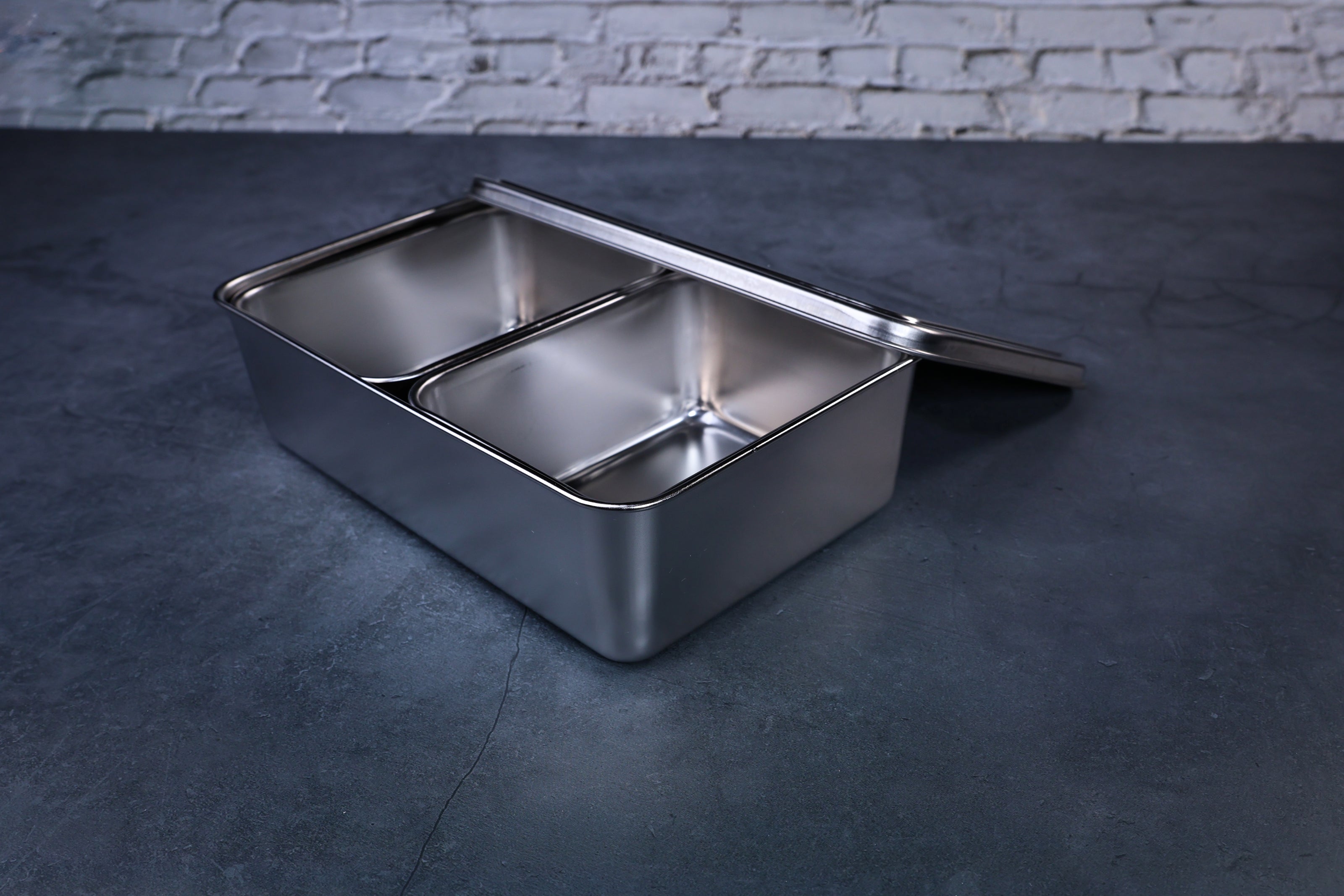 Yakumi 2-compartment condiment pan with lid propped open, stainless steel compartments visible inside