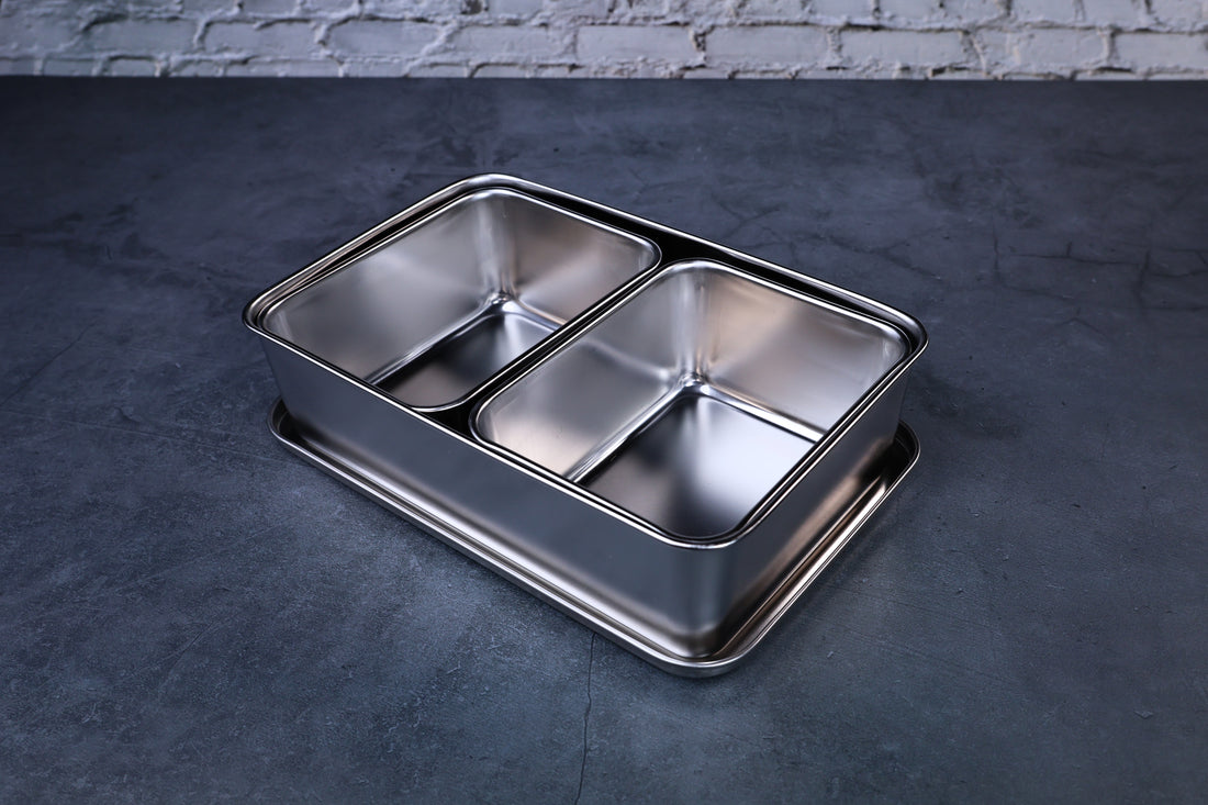 Yakumi 2-compartment condiment pan open, showing both stainless steel inserts, angled overhead view