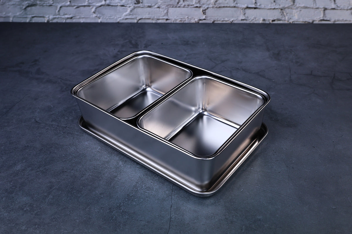 Yakumi 2-compartment condiment pan open, showing both stainless steel inserts, angled overhead view