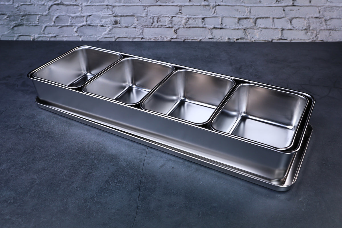 Yakumi 4-compartment condiment pan — angled overhead view showing all four stainless steel compartments