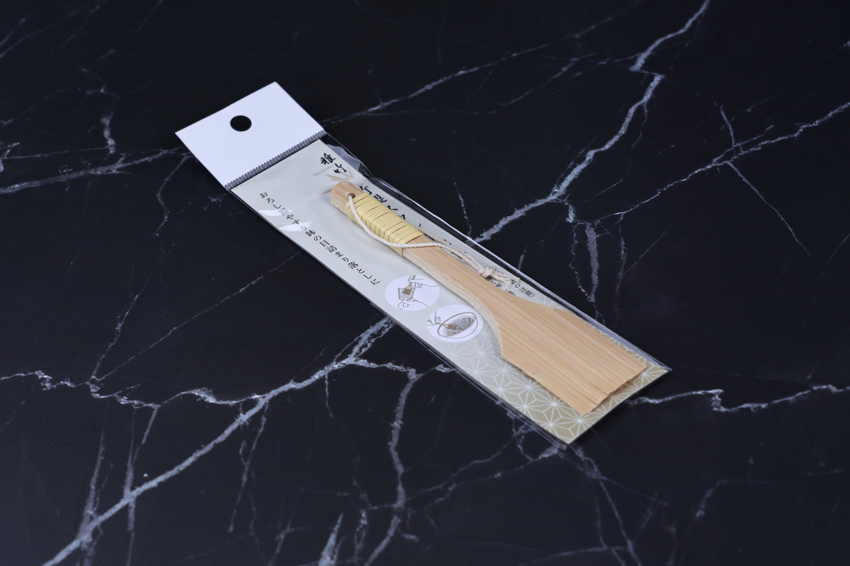 Yakumiyose bamboo brush 13cm — angled view in packaging showing full brush length on dark marble