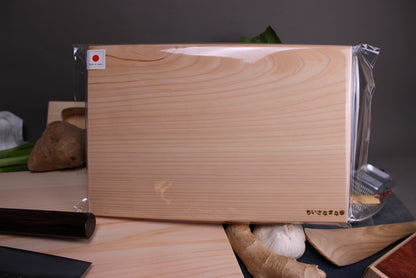 little hinoki cutting board in kitchen with vegetables larger cutting boards knives spoon