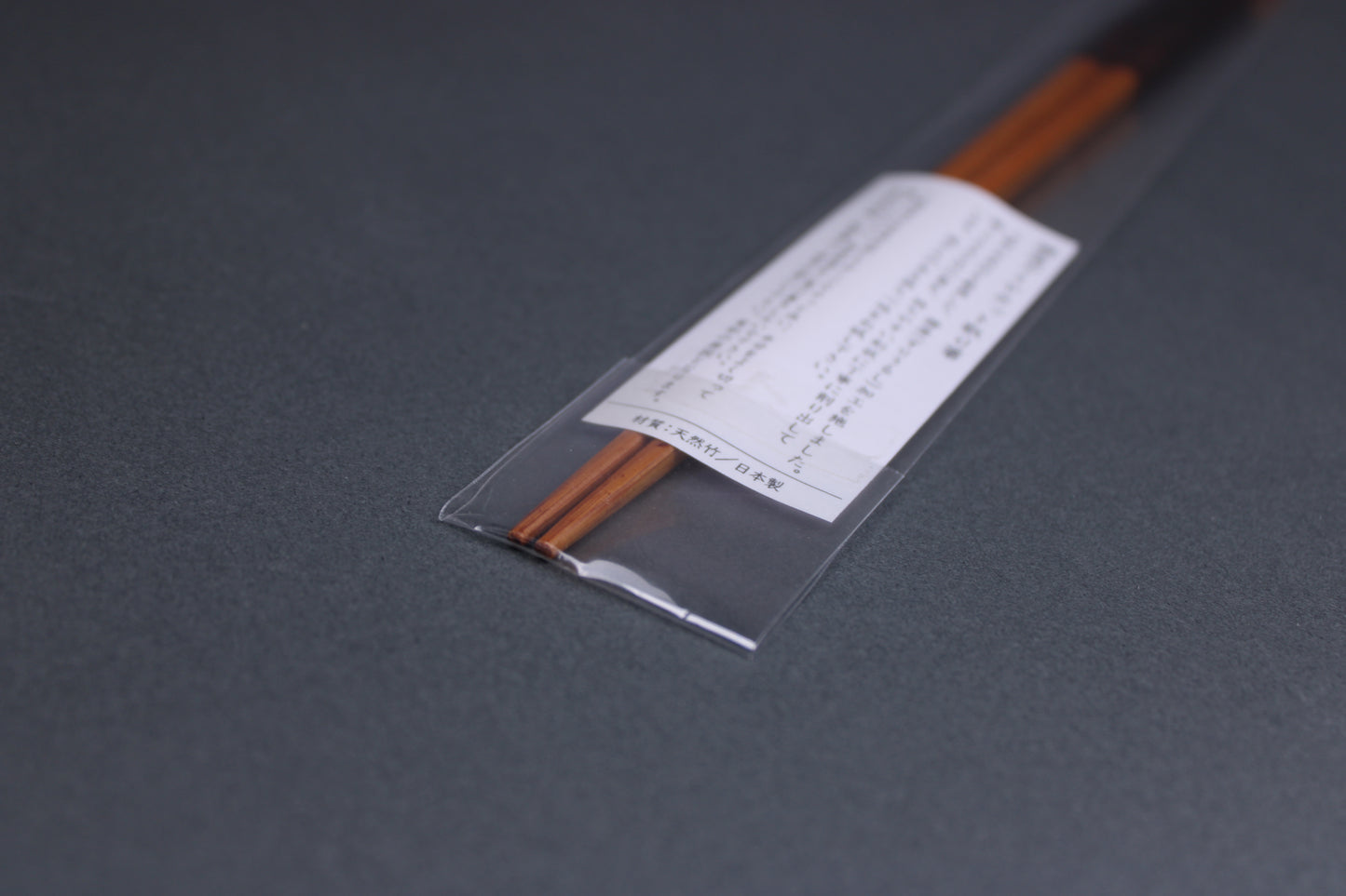 long square brownish tan bamboo cooking chopsticks urushi lacquered in clear packaging white product paper description pointed tips in hiragana grey backdop