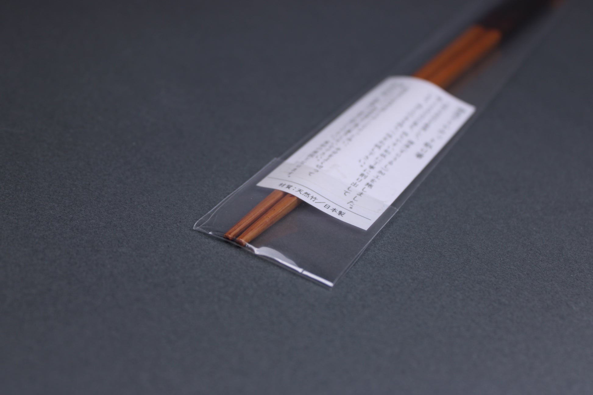 long square brownish tan bamboo cooking chopsticks urushi lacquered in clear packaging white product paper description pointed tips in hiragana grey backdop