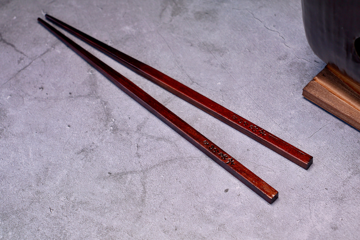 Yamacoh Suri Urushi Chopsticks Hinoki 22cm, pair on concrete with kanji engraving visible along both shafts