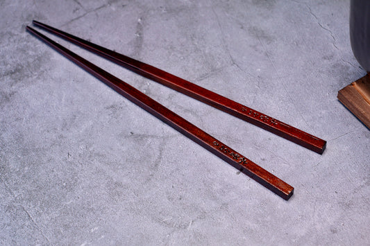 Yamacoh Suri Urushi Chopsticks Hinoki 22cm, pair laid diagonally on concrete showing full length and kanji engraving