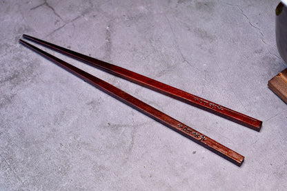 Yamacoh Suri Urushi Chopsticks Hinoki 22cm, pair showing deep urushi lacquer finish on concrete surface