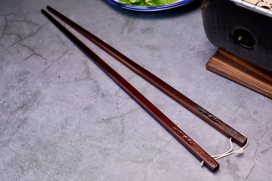 Yamacoh Suri Urushi Cooking Chopsticks Hinoki 33cm, pair on concrete showing urushi lacquer body texture and engraved kanji