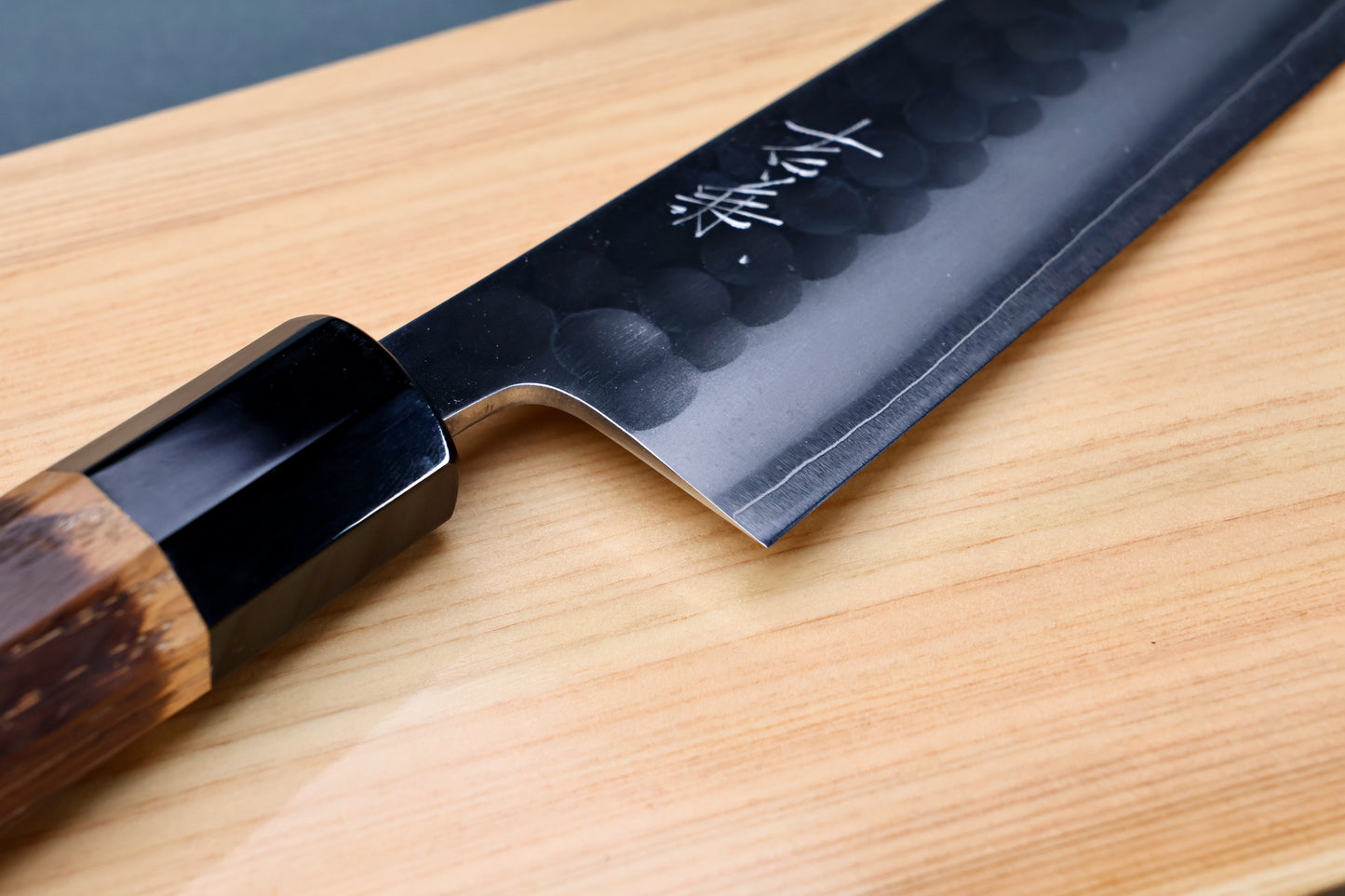 Yoshikane SKD Tsuchime Gyuto 210mm heel and choil on hinoki board showing kanji engraving and buffalo horn collar