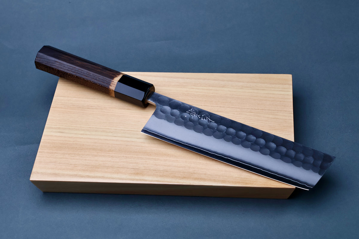 Yoshikane SKD Tsuchime Nakiri 165mm resting on hinoki cutting board showing full blade and handle profile