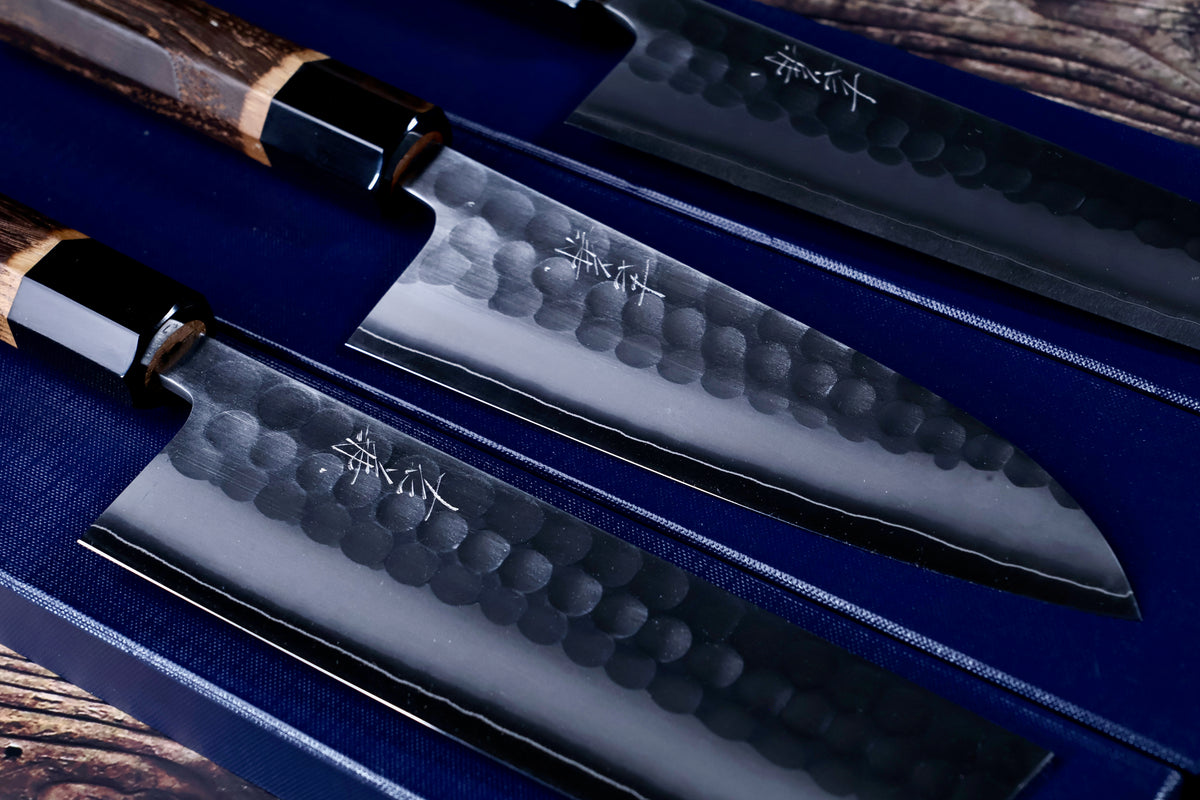 Close-up of Yoshikane SKD Tsuchime gyuto, santoku and nakiri blades showing hammered finish and kanji engraving