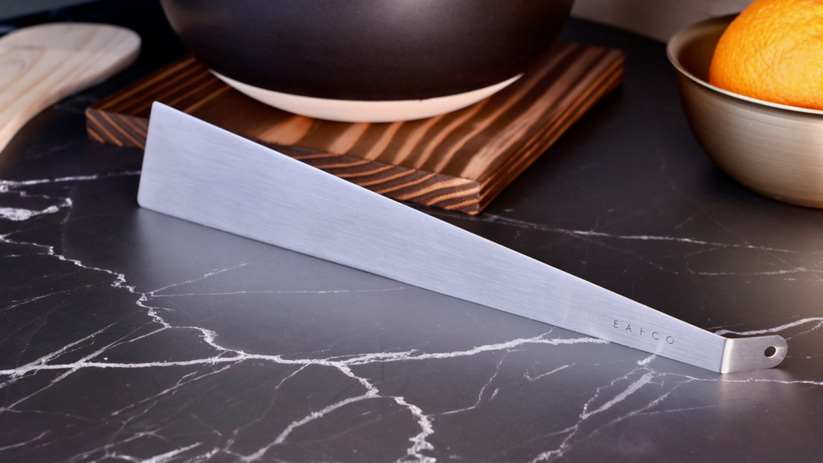 Yoshikawa EATCO Tolu Spatula — stainless steel blade full profile on dark marble surface